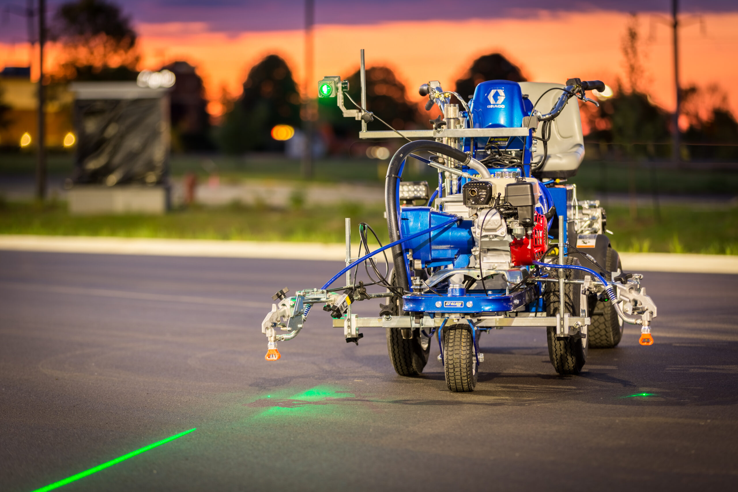 Image of construction equipment showing laser on roadway for painting straight lines