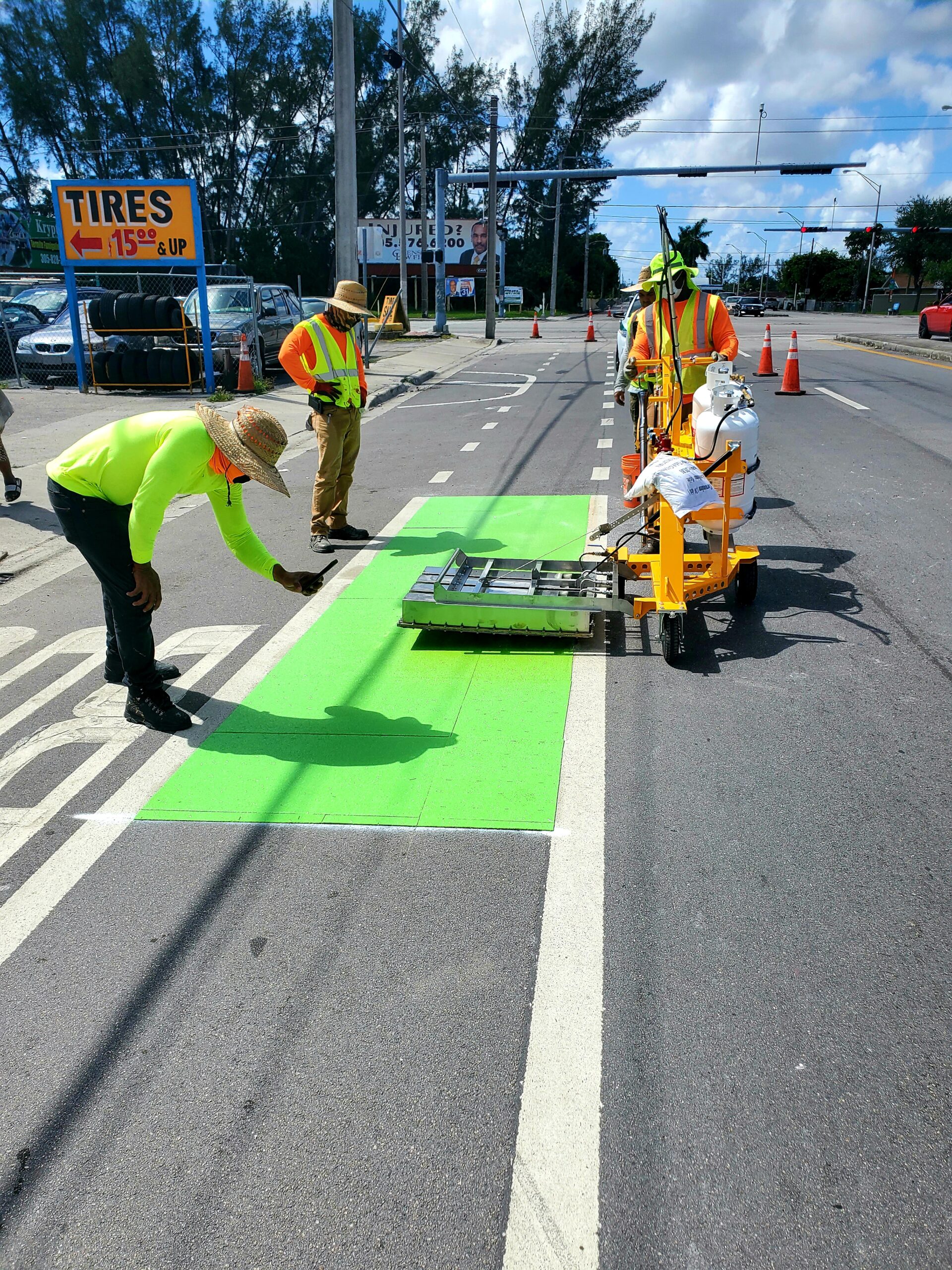 2 men working on painting safety stripes and lanes on the road